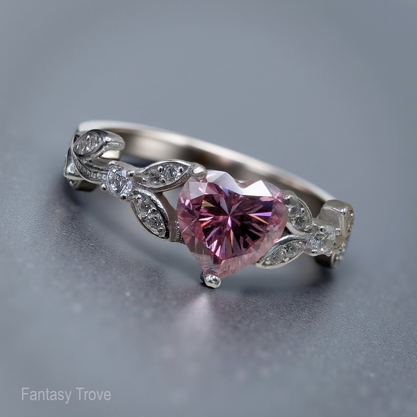 Silver ring with a pink heart-shaped gemstone on a gray background