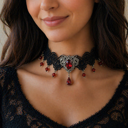 Close-up of a woman wearing a black lace choker with red gemstones.