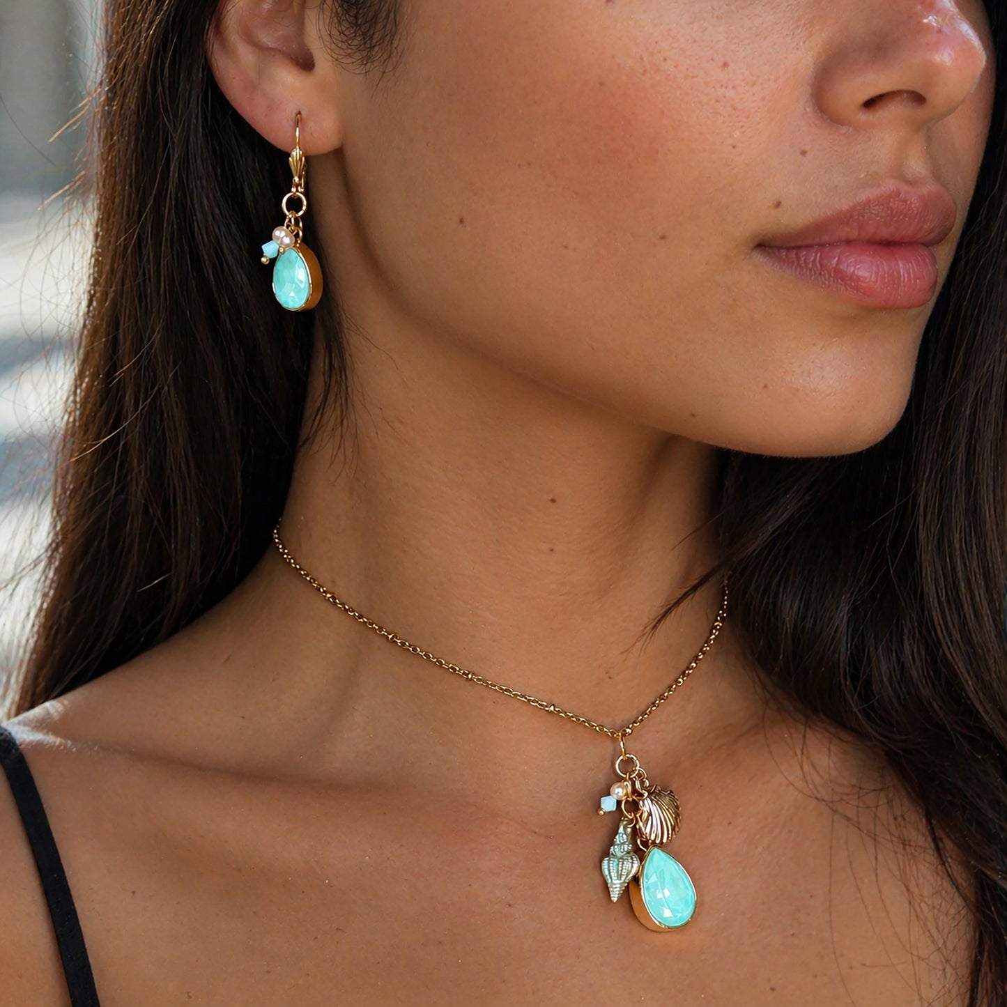 Close-up of a woman wearing a gold necklace with Swarovski mint green pendants.  Mermaid Bride Jewelry