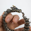 Silver dragon bracelet on a hand with a plain background