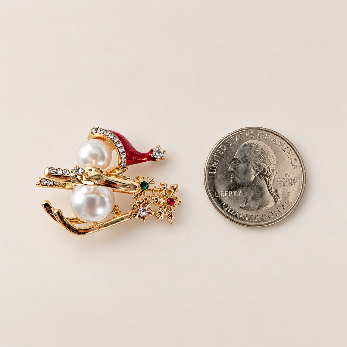 Snowman on sled holiday Christmas brooch next to US quarter