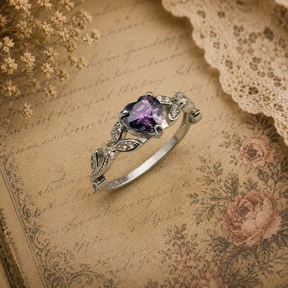 Sterling Silver ring with a purple Amethyst gemstone on an old book with floral patterns