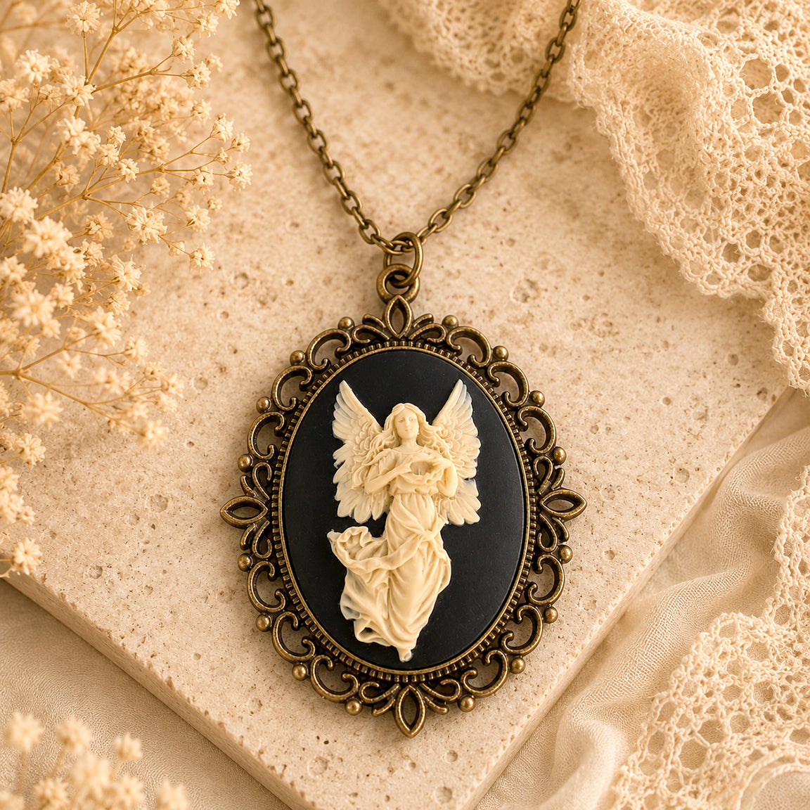 Vintage-style angel cameo pendant necklace on a textured surface with delicate flowers.