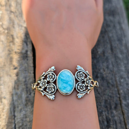 Blue Amazonite Ocean stone bracelet with a blue stone on a wrist against a wooden background.  Boho jewelry