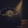 Decorative brass flower bracelet on a dark blue cushion with a spotlight effect