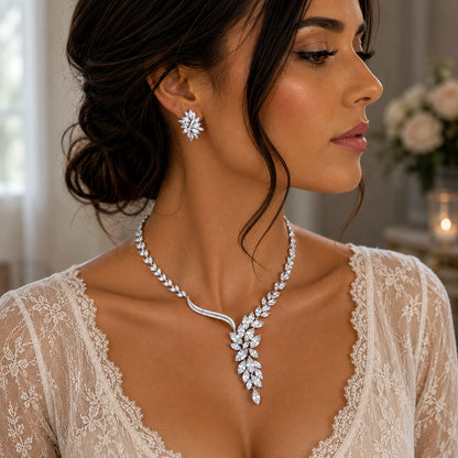 Woman wearing a nature inspired diamond cubic zirconia necklace with leaf detail and earrings in a soft-focus background