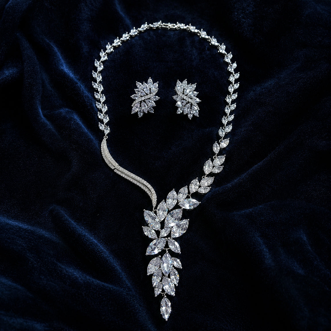Diamond cubic zirconia necklace and earrings on a dark blue velvet background