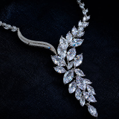 Silver necklace with leaf-shaped diamond pendants on a black background