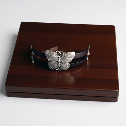 Butterfly-themed bracelet on a wooden box with a white background