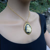 Virgin Mother Mary Kissing the Head of Baby Jesus Cameo brooch pendant being worn as a necklace on model
