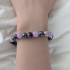 Bracelet with multicolored beads on a wrist against a neutral background