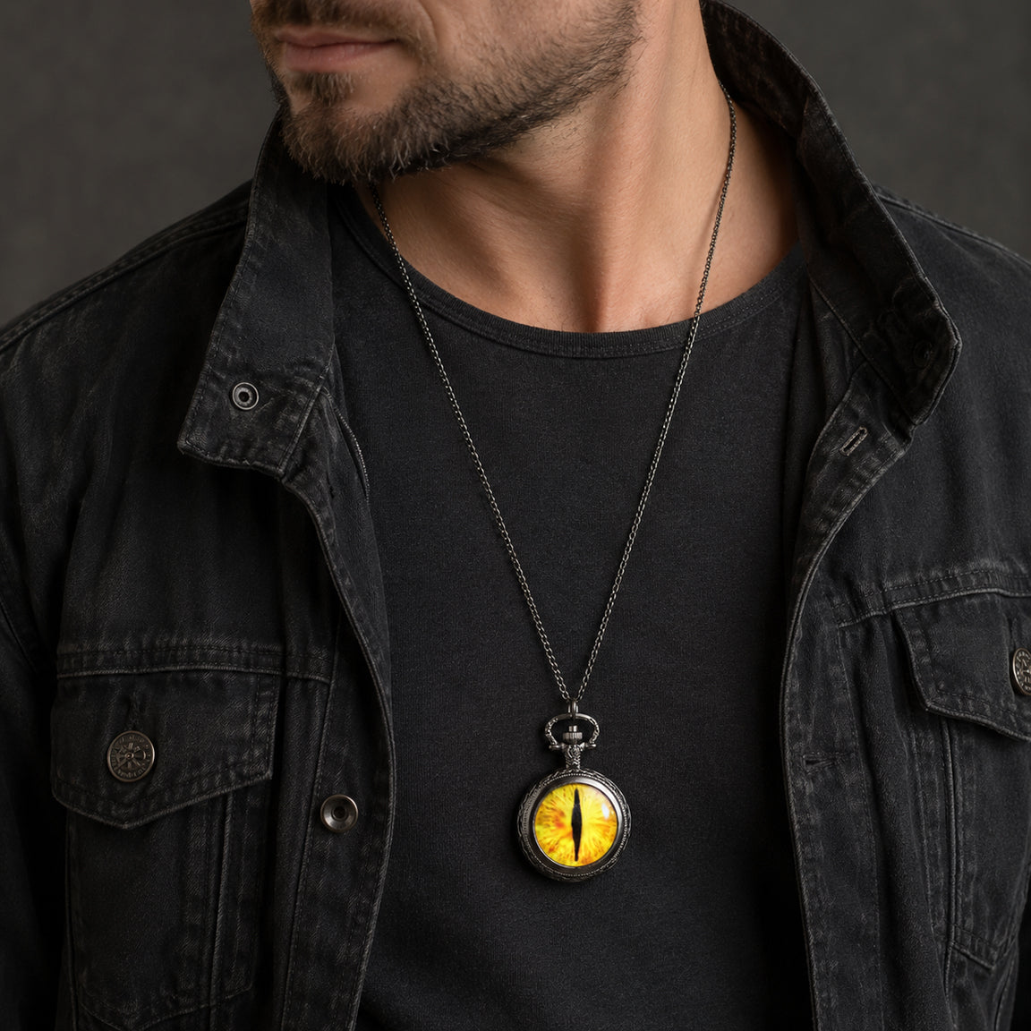 Man wearing a black jacket and black shirt with a distinctive dragon eye of Sauron pocket watch necklace.  Gothic Fantasy Jewelry.
