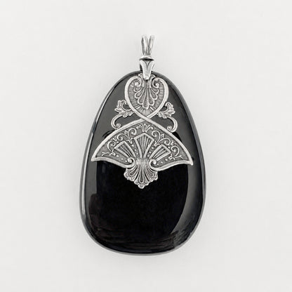 Black druzy stone pendant with silver decorative Art Dedco design on a white background.