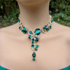 emerald Green crystal floral necklace on a mannequin with a blurred green background