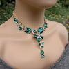 Necklace with emerald green and clear crystals on a mannequin
