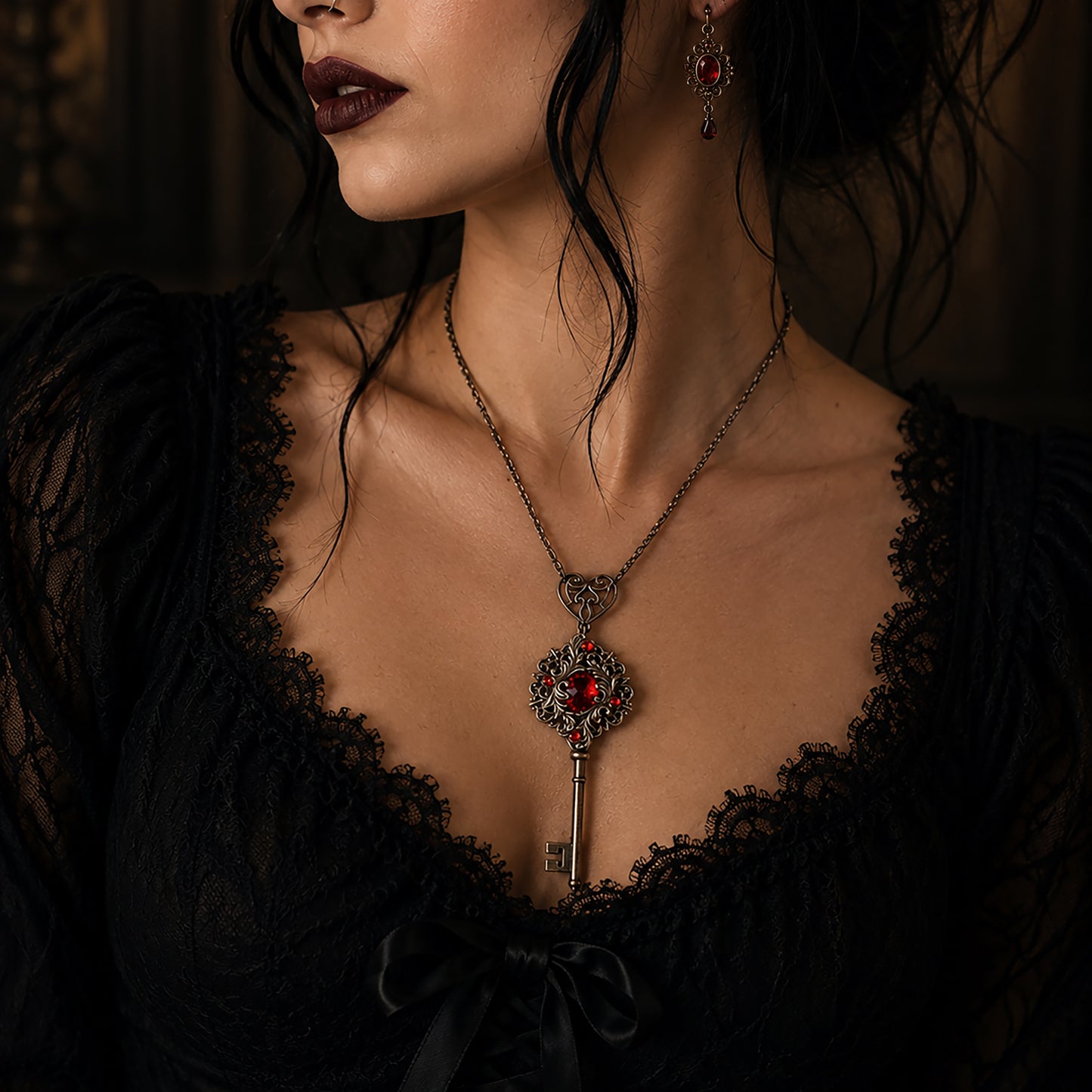 Close-up of a woman wearing a dark, ornate necklace with a key pendant.  Vintage Fairycore Key Necklace with Red Swarovski Crystal – Gothic Fantasy Jewelry