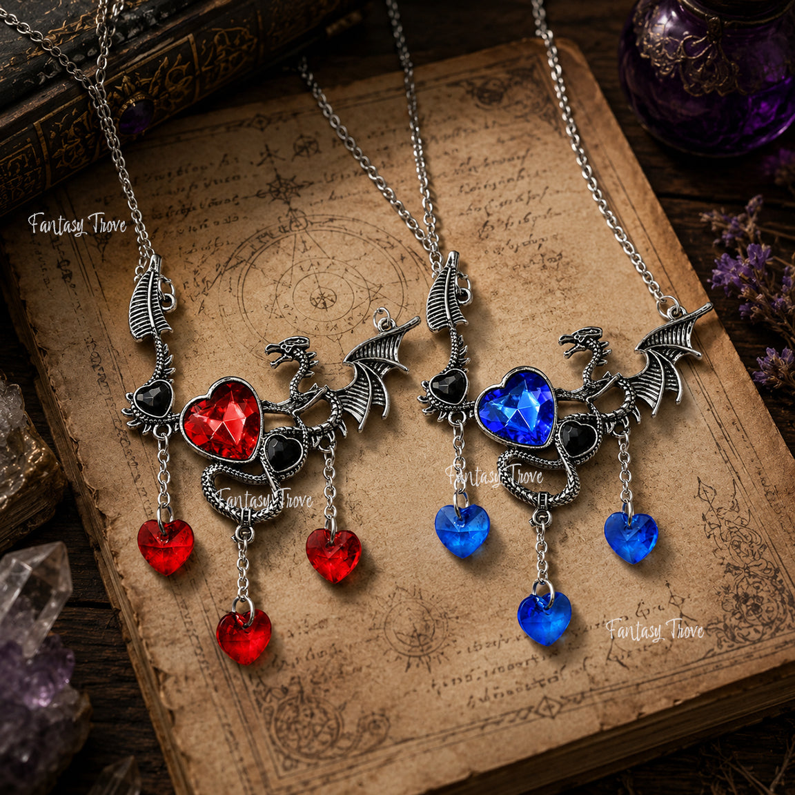 Two dragon-shaped necklaces with red and blue heart pendants on an old book.  Gothic romance dragon fantasy jewelry.
