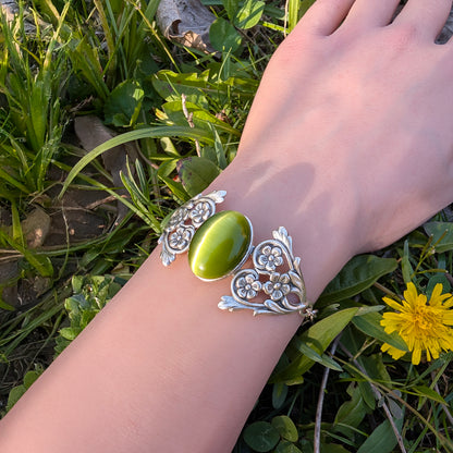 Olivine Cats Eye Sterling Silver Floral Green Glass Victorian Fairy Boho Bracelet on arm, outside.