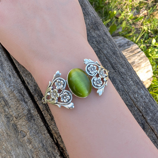 Olivine Cats Eye Sterling Silver Floral Green Glass Victorian Fairy Boho Bracelet on wrist, outside.