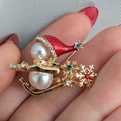 Snowman on sled holiday Christmas brooch held in hand