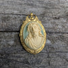 Gold-framed pendant with a 3D portrait of Jesus on a wooden surface