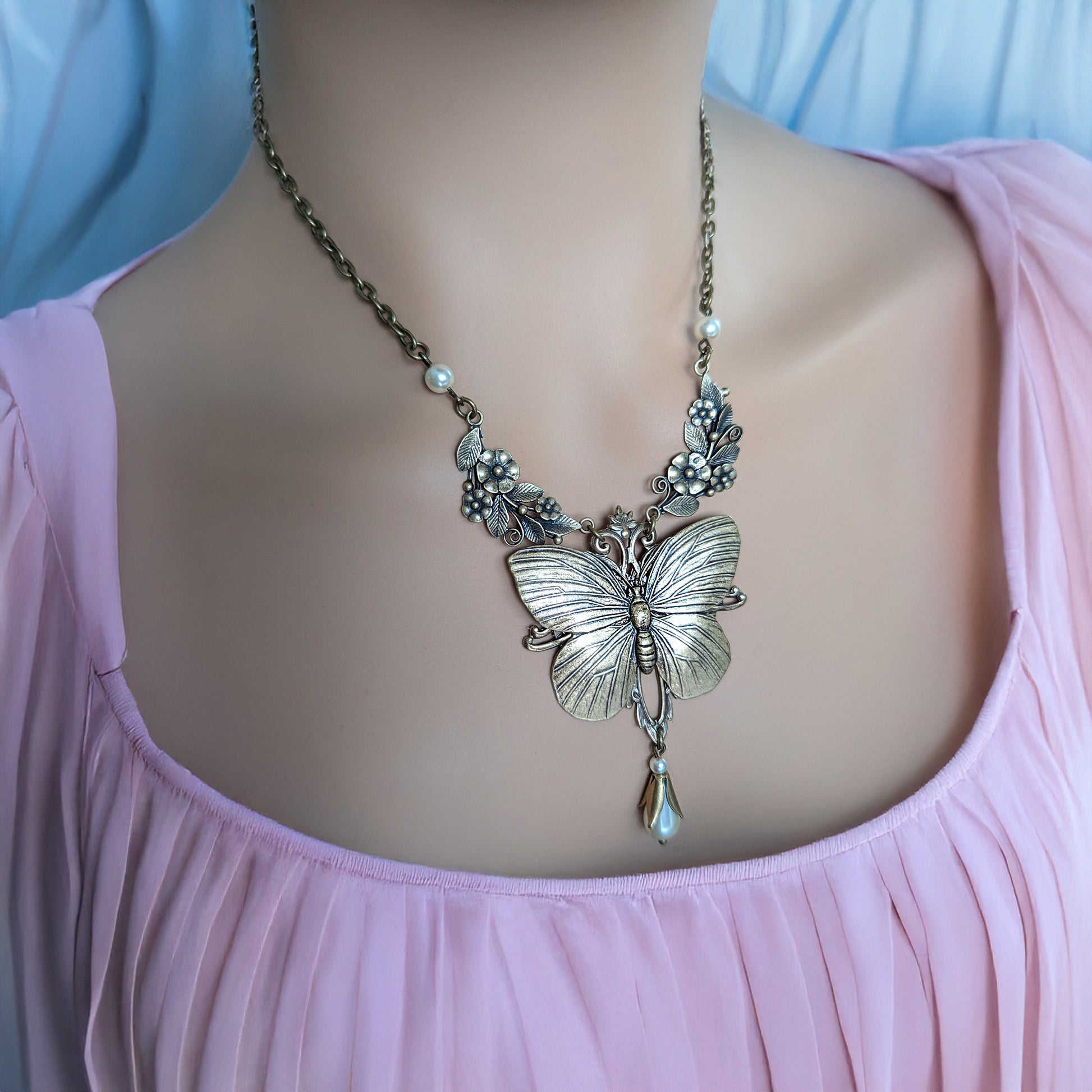 Vintage Whimsical Butterfly necklace pendant on a model with a pink top
