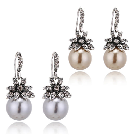silver and gold pearl drop earrings with rhinestone flowers on white background