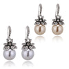 silver and gold pearl drop earrings with rhinestone flowers on white background