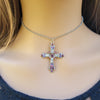 Silver cross necklace with colorful stones on a model