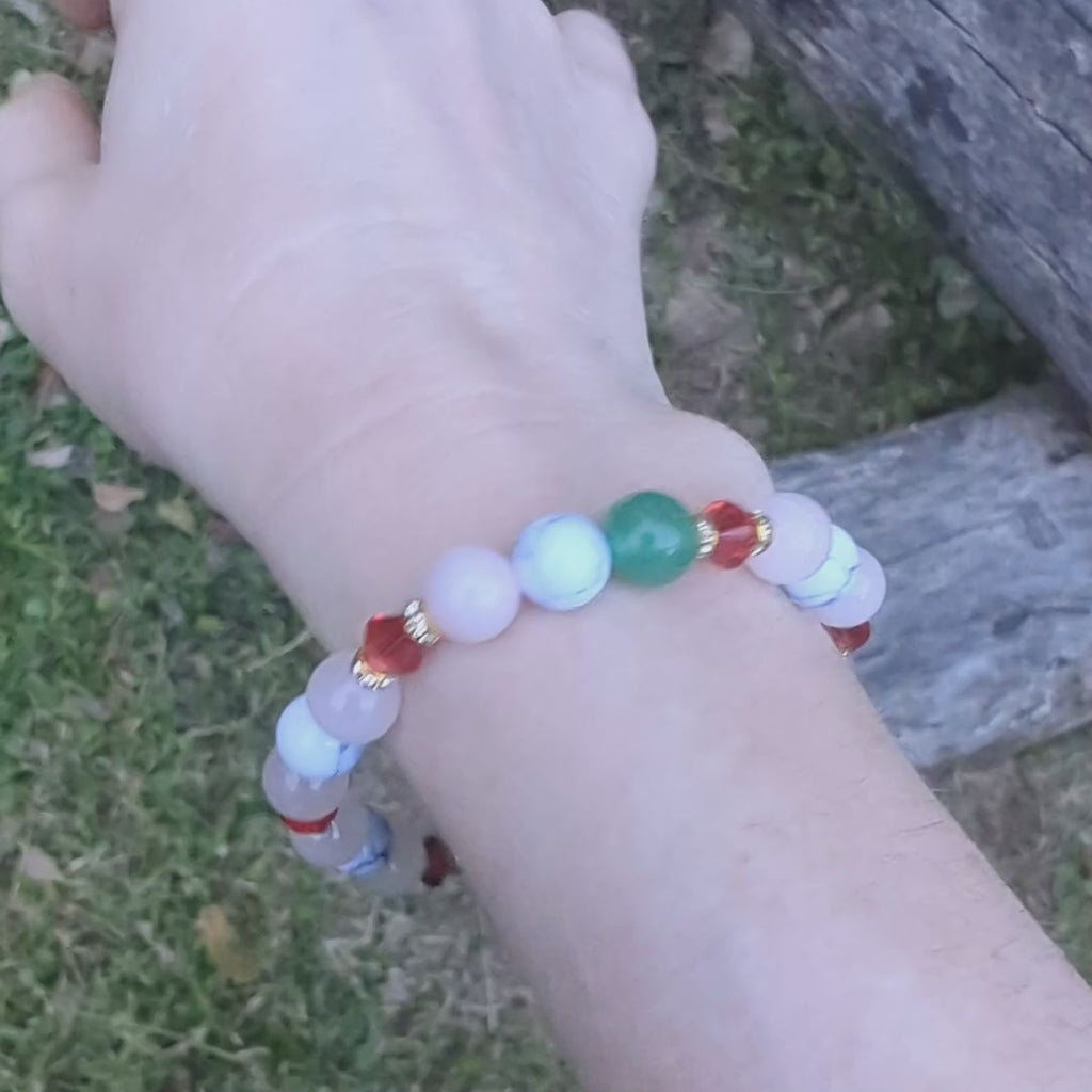 Holiday beaded natural stone stretch bracelet made with rose quartz, green aventurine and white howlite beads, accented by red Swarovski crystals on wrist