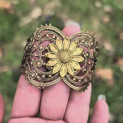 Vintage style brass floral sunflower statement bracelet against hand