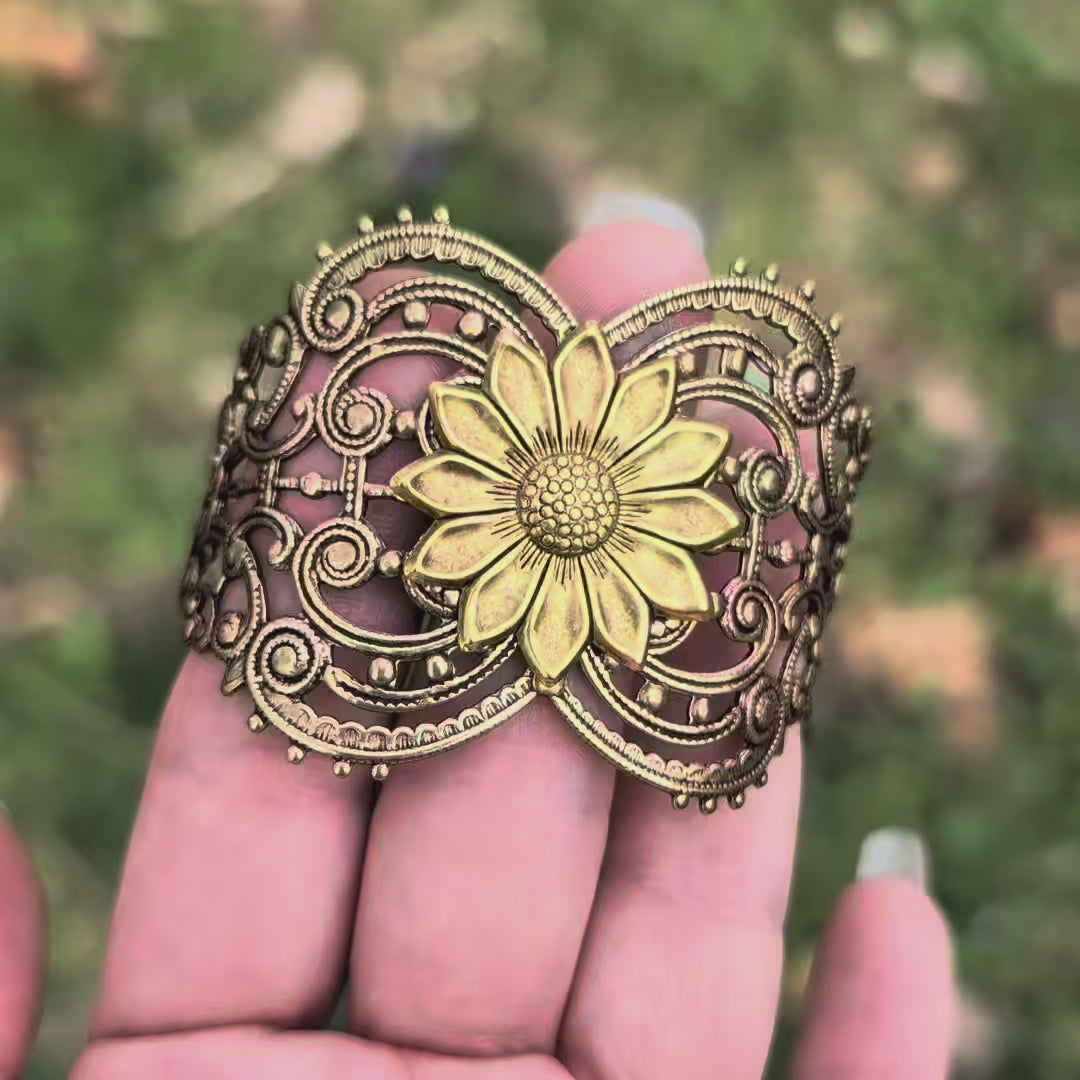 Vintage style brass floral sunflower statement bracelet against hand