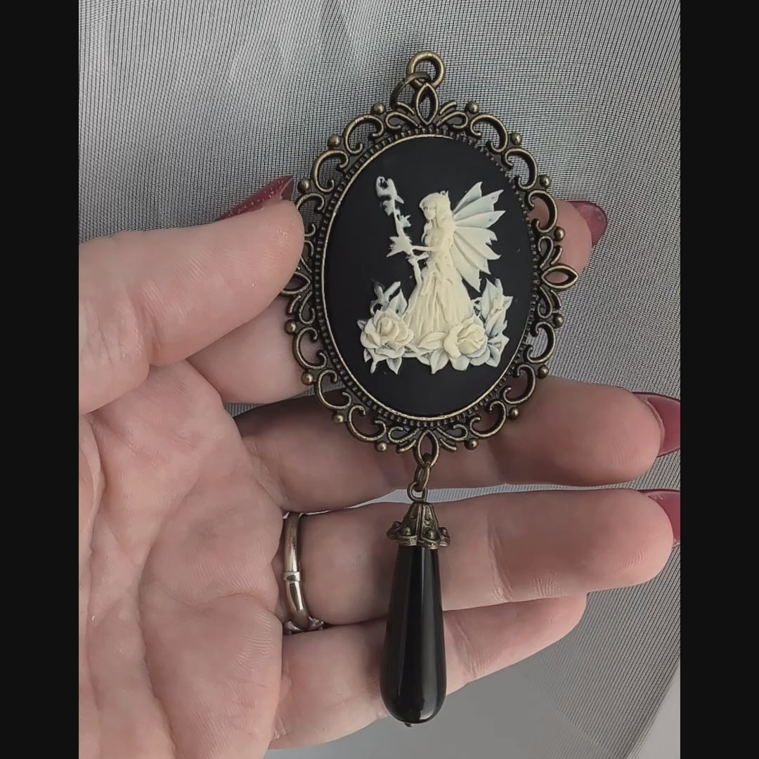 Vintage Fairy princess cameo pendant with black onyx drop bead held in hand.  Fairycore fantasy jewelry