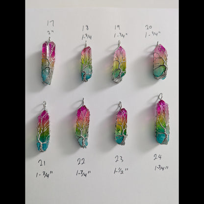 Natural Rainbow quartz crystal tree of life wire wrapped pendants arranged in rows on a white background