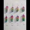 Natural Rainbow quartz crystal tree of life wire wrapped pendants arranged in rows on a white background