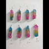 Natural Rainbow quartz crystal tree of life wire wrapped pendants arranged in rows on a white background