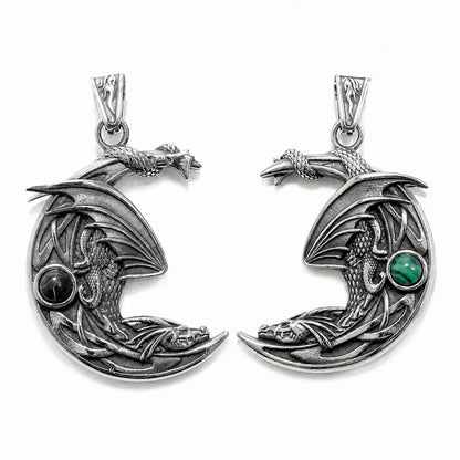Double sided silver dragon pendant in the shape of a crescent moon with green and back gemstones on a white background.  Dragon lover fantasy jewelry