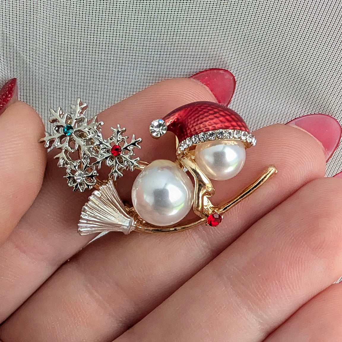 Snowman on broom holiday Christmas brooch held in hand
