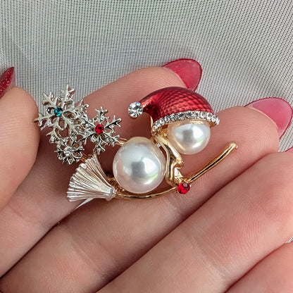 Snowman on broom holiday Christmas brooch held in hand
