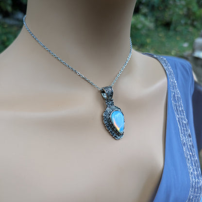 Necklace with a blue pendant on a mannequin against a blurred green background