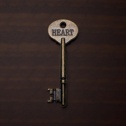 Vintage key with 'HEART' engraved on a dark brown background