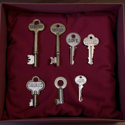 Set of decorative keys with inscriptions on a red fabric background