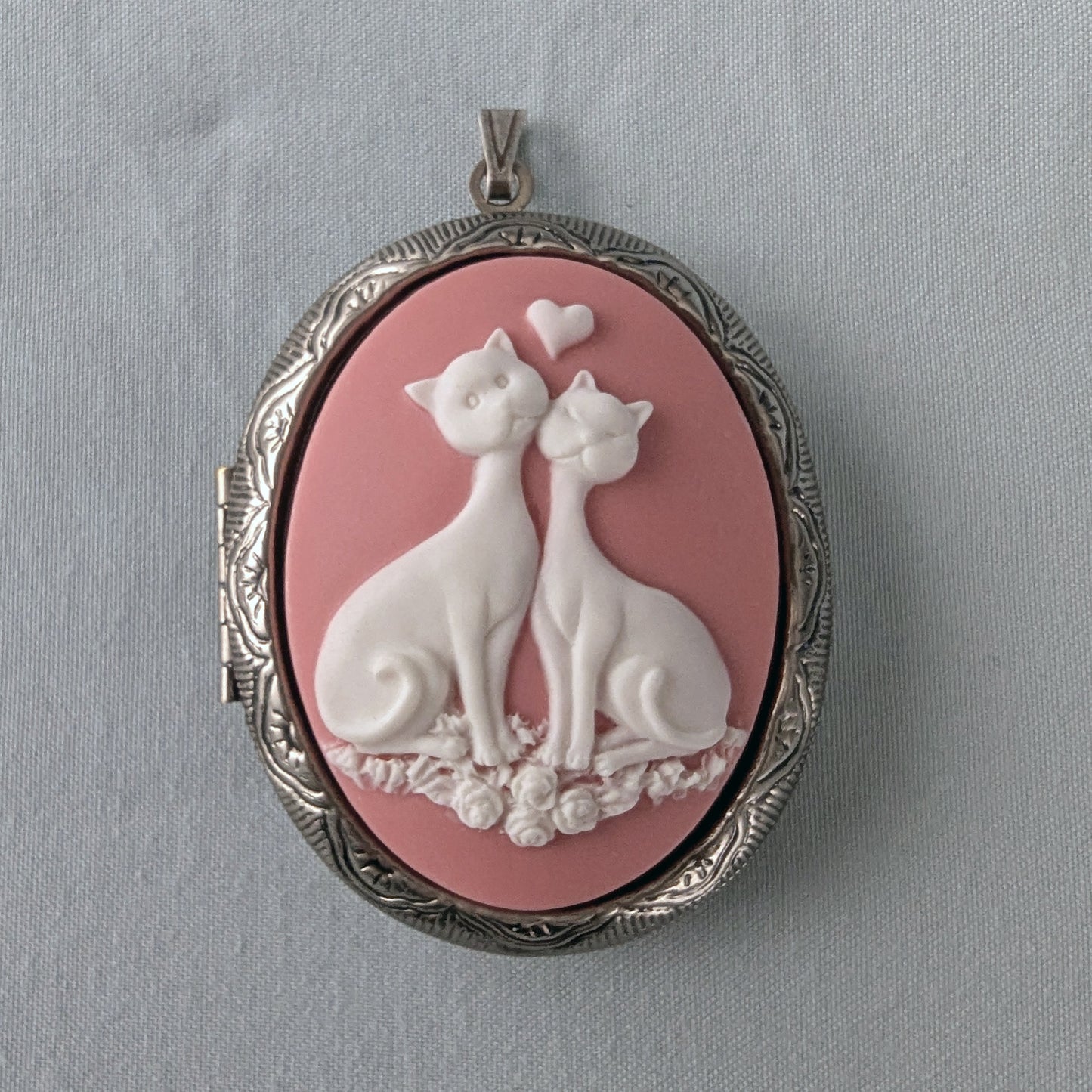 Pink and white cat lovers cameo necklace on silver locket.