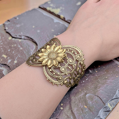 Vintage style brass floral sunflower statement bracelet on a wrist