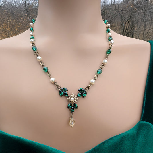 Vintage Art Deco Swarovski Emerald crystal and pearl floral necklace on a model with a blurred natural background