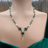 Vintage Art Deco Swarovski Emerald crystal and pearl floral necklace on a model with a blurred natural background