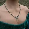 Vintage Art Deco Swarovski Emerald green crystal and pearl floral necklace on a model wearing a green top.