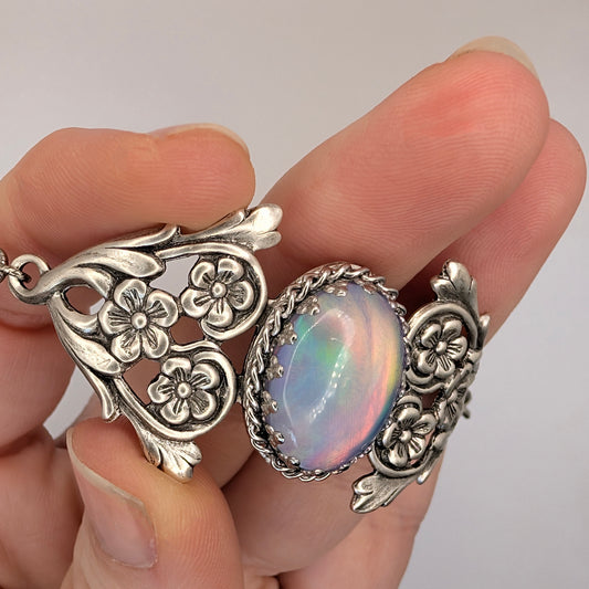 Vintage Fairycore Aurora Rainbow Opal Silver Floral Bracelet in hand, inside light.