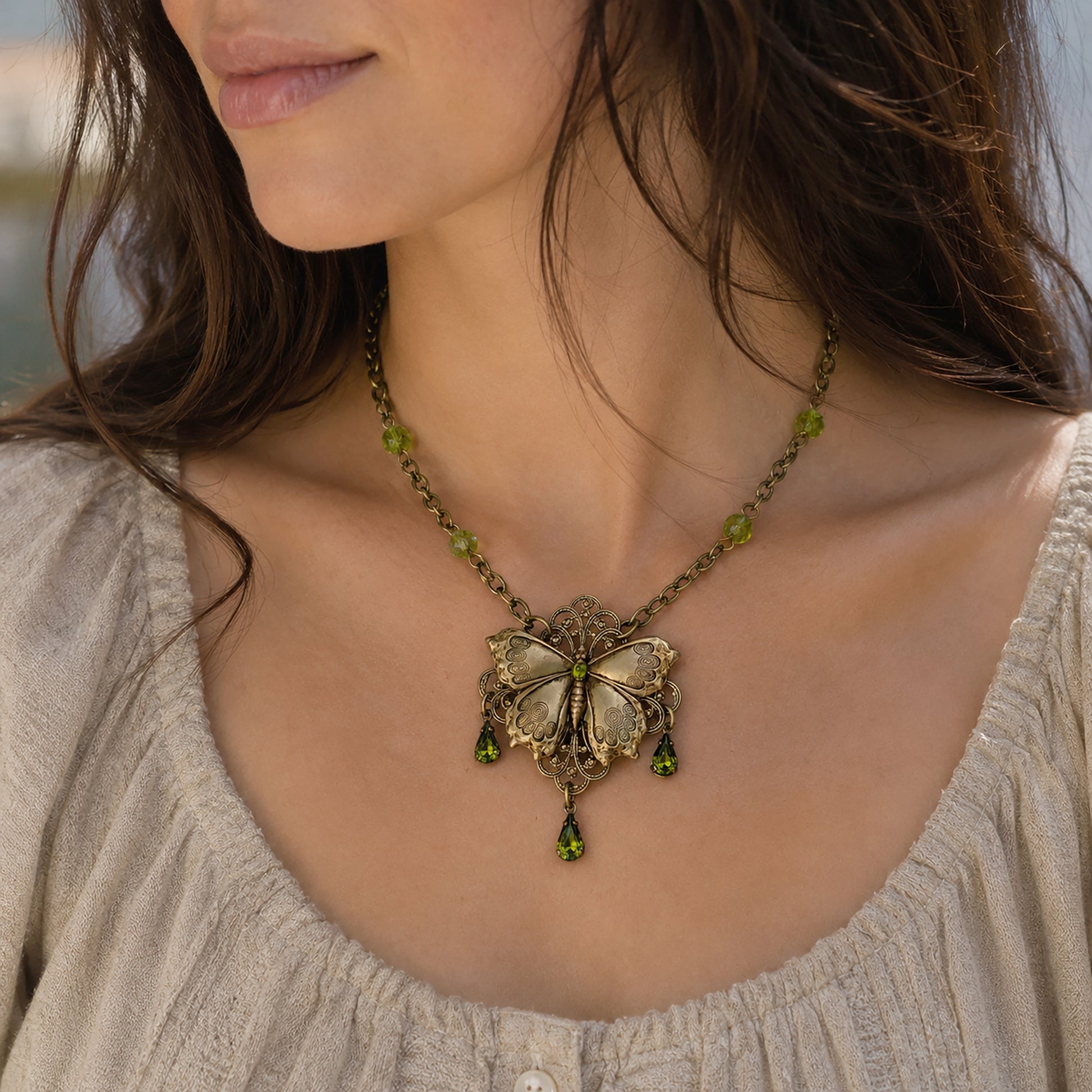 Brass Vintage Cottagecore Butterfly necklace with olivine gemstones on a woman