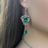 Matching brass earrings with emerald Swarovski crystals and floral scrollwork design